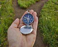 Hand holding a compass