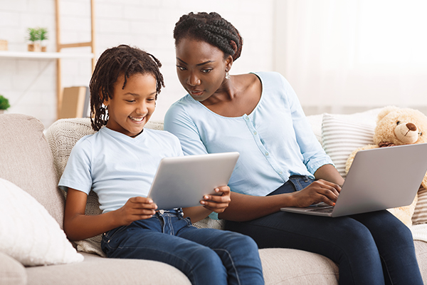 Mère et fille regardant ensemble quelque chose en ligne.